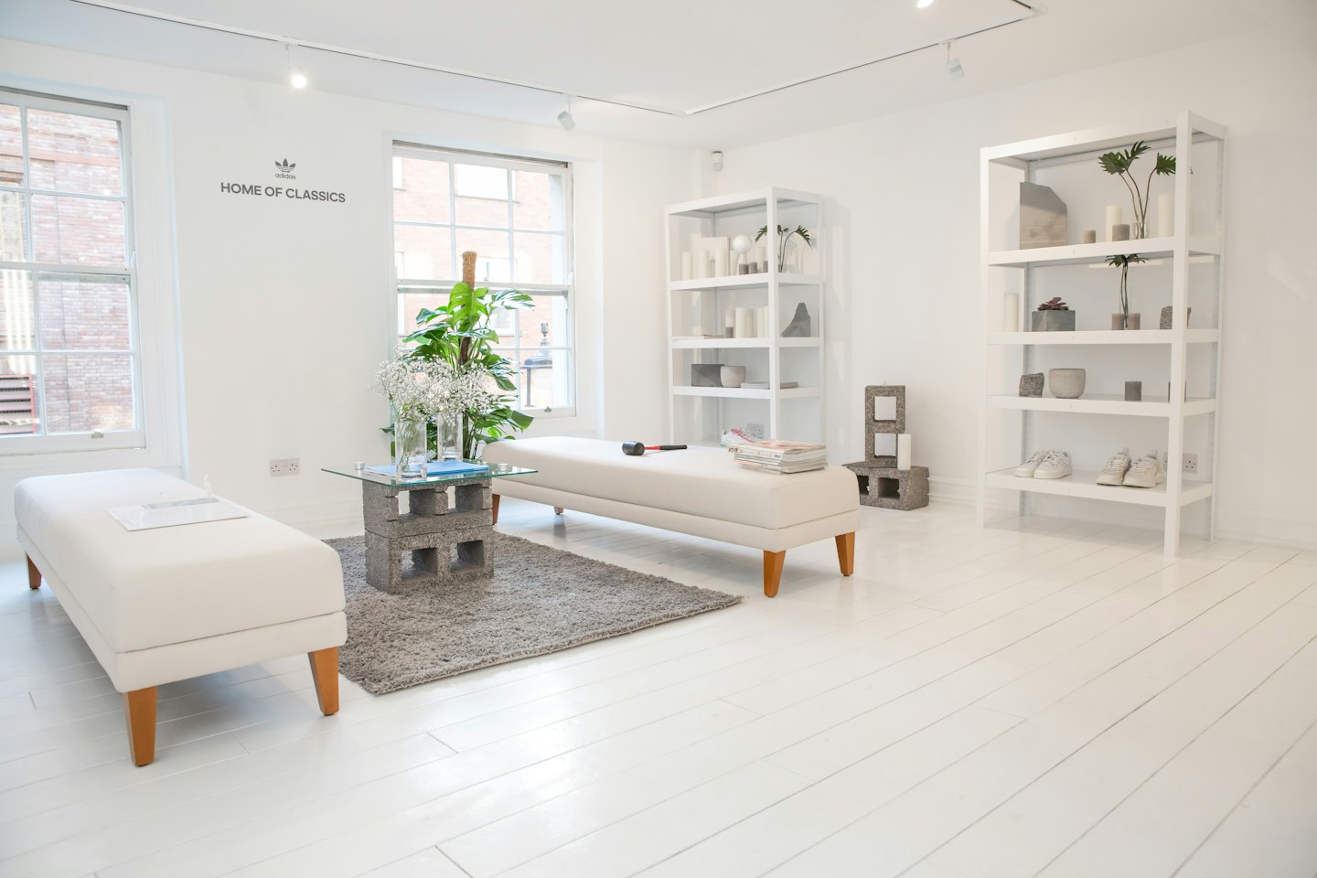 Moderner Showroom mit weißen Bänken und Tischen aus Hohlblocksteinen.