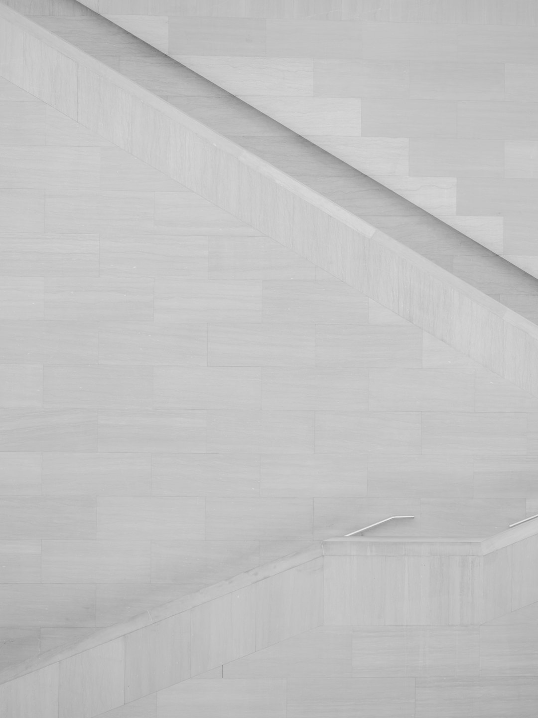Moderne Architekturtreppe mit hell gefliesten Wänden.